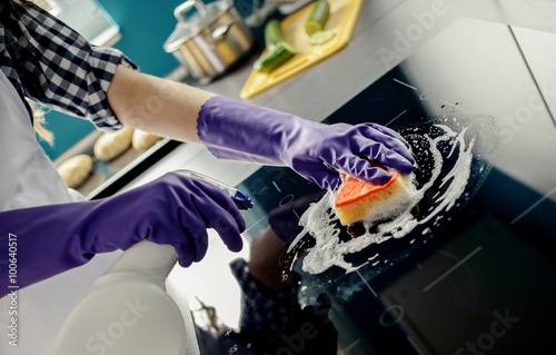 female hands washes the induction hob