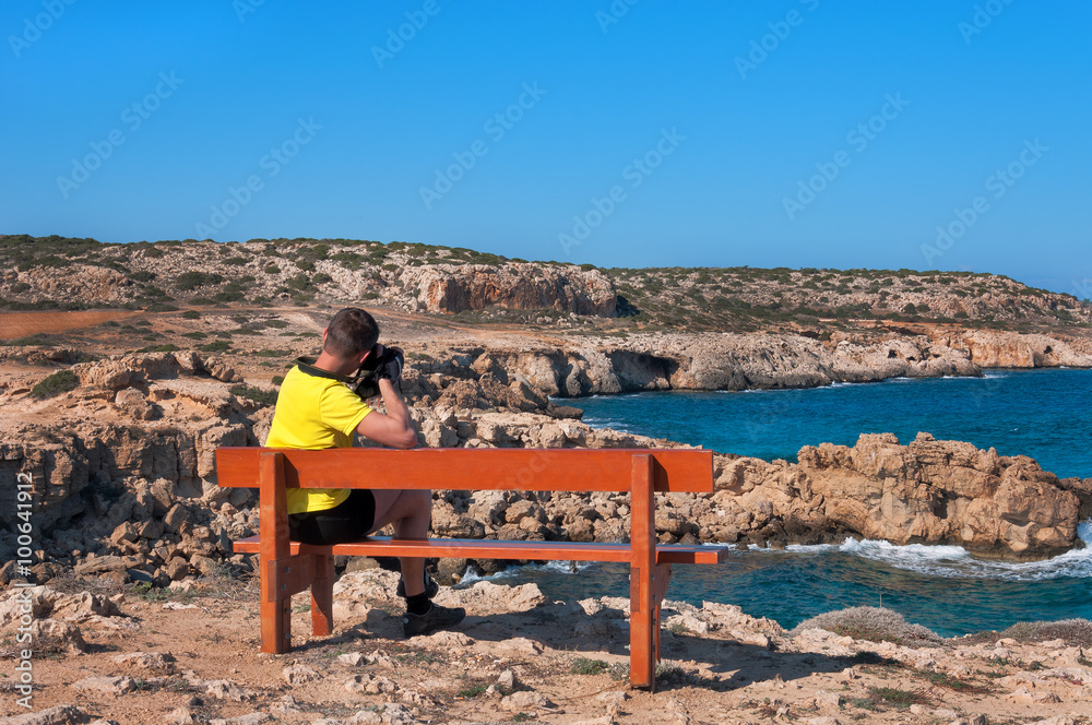 man on bench pictures of the Mediterranean Sea.