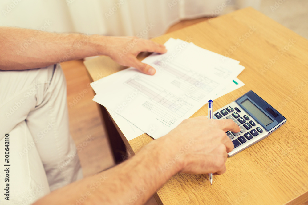 close up of man with papers and calculator at home close up of man with papers and calculator at home