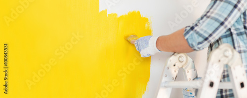 close up of male in gloves painting a wall