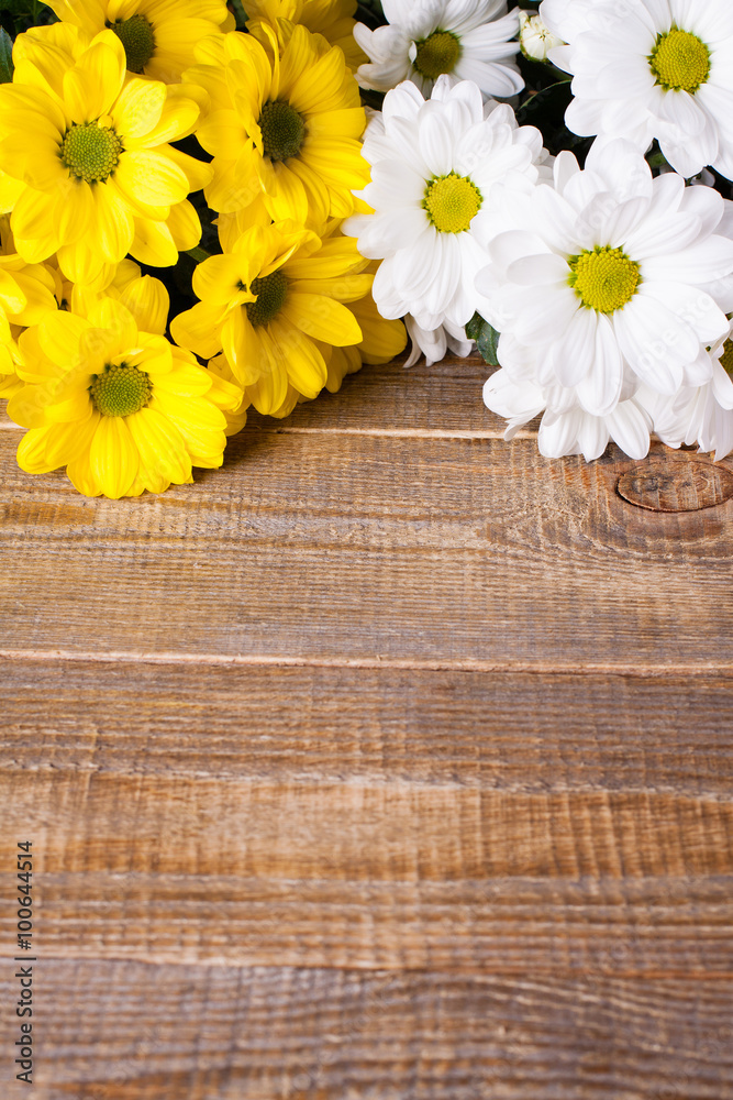 Obraz premium White and yellow oxeye daisy flowers bouquet on wooden background.
