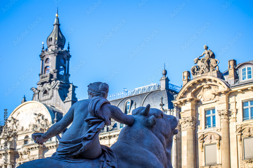 Fototapeta premium Wittelsbacher Brunnen in München vor der prächtigen Fassade der alten Börse an einem wolkenlosen Herbsttag