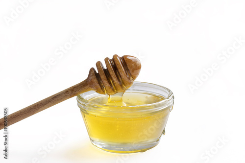 Jar of honey with a wooden drizzler, lemon and anise on the wooden backgrond
