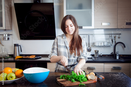 hand of a woman housewife preparing dinner   lettuce on cutting board in kitchen