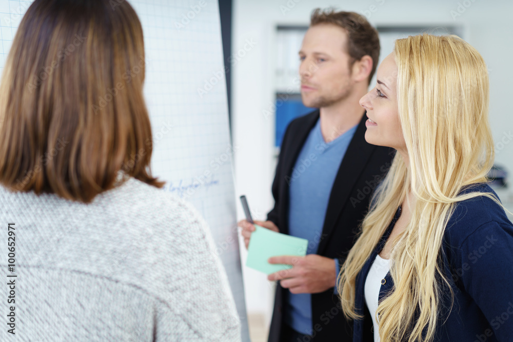 kollegen arbeiten zusammen am flipchart und besprechen neue ideen kollegen arbeiten zusammen am flipchart und besprechen neue ideen
