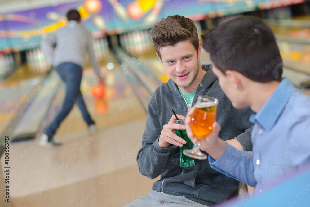 Two men having a drink at the bowling alley