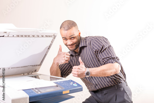Foto happy successful man in office near copier