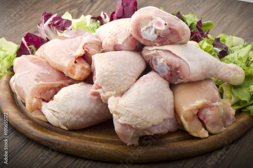 Fresh skinless chicken thighs and legs on cutting board