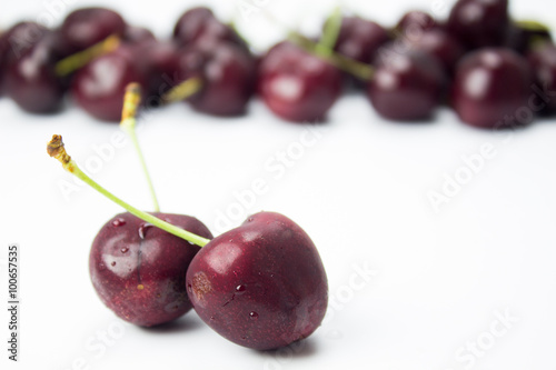 A closeup couple of cherries and group of cherries on background