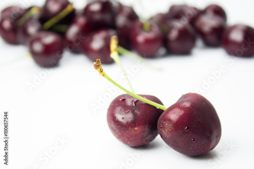 A closeup couple of cherries and group of cherries on background