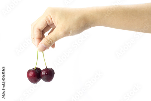hand holding the two fresh cherries on white background