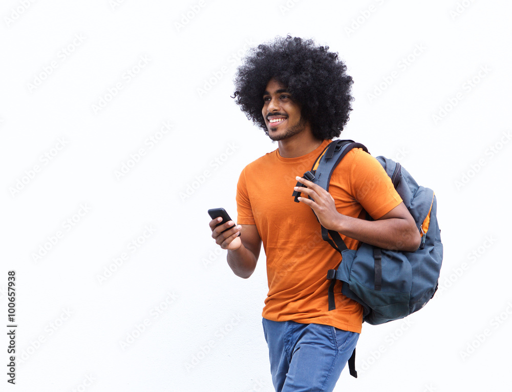 Smiling african american man walking with bag and cellphone Smiling african american man walking with bag and cellphone