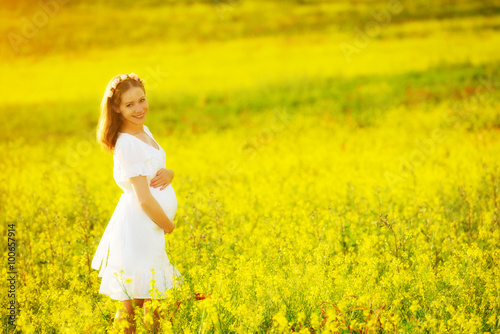 beautiful pregnant woman in summer nature meadow with yellow flo © JenkoAtaman