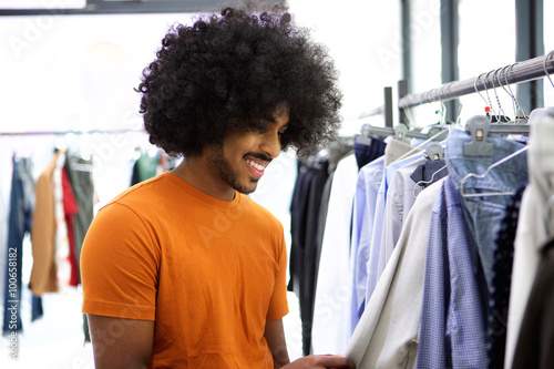 Man with afro looking for clothes in store
