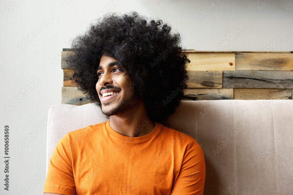 Smiling young black man with afro looking away
