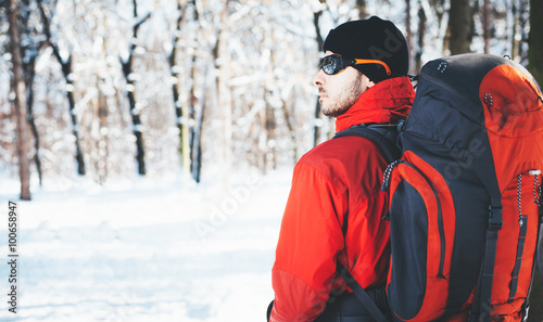 Man hiking at winter mountain/Man hiker trekking in snow forest at winter mountain. Healthy lifestyle winter adventure