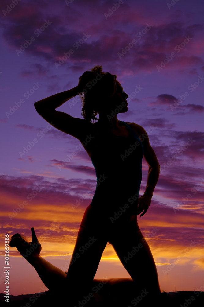 silhouette of a woman in a purple sunset on knees