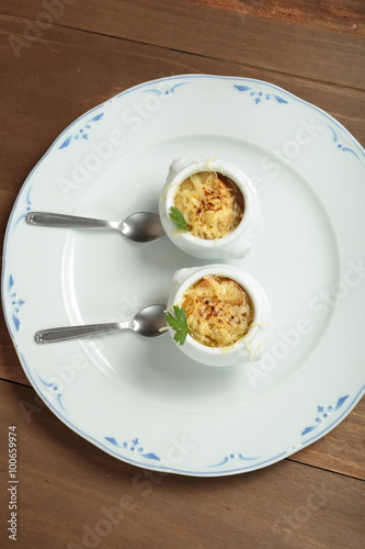 Onion soup served in porcelain bowls 