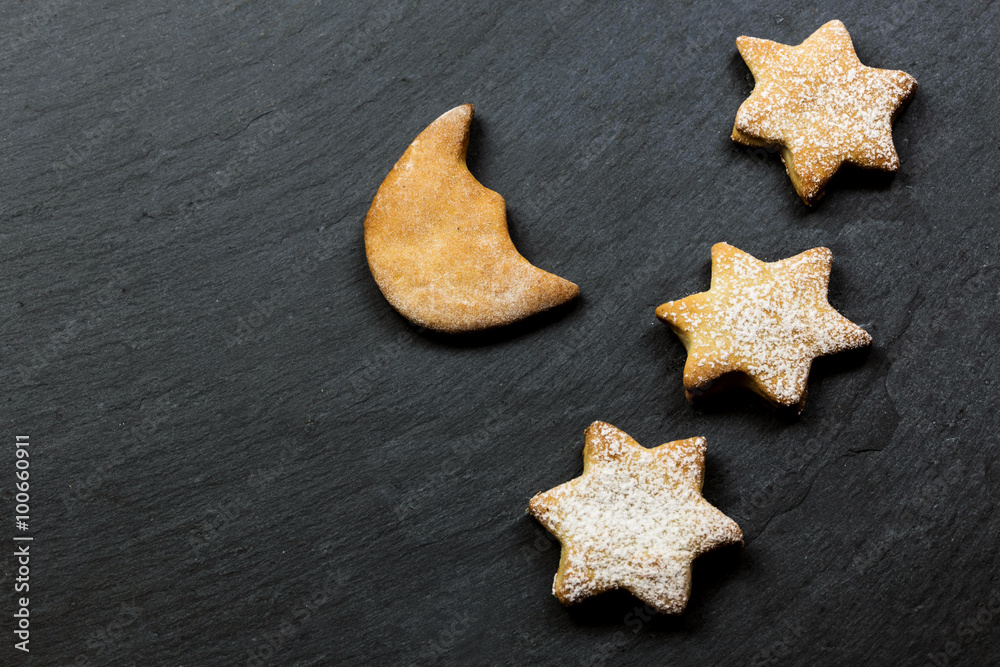three stars cookies with moon shape cookie over slate background three stars cookies with moon shape cookie over slate background