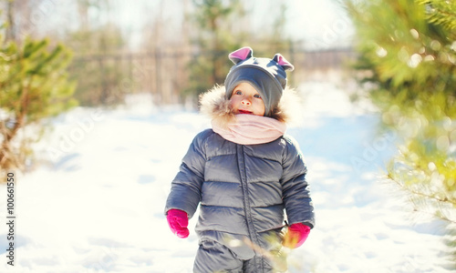 Cute little child on snow walking in sunny winter day