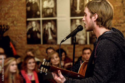 Valokuva stylish vocalist with beard performing lyrical song on stage wit