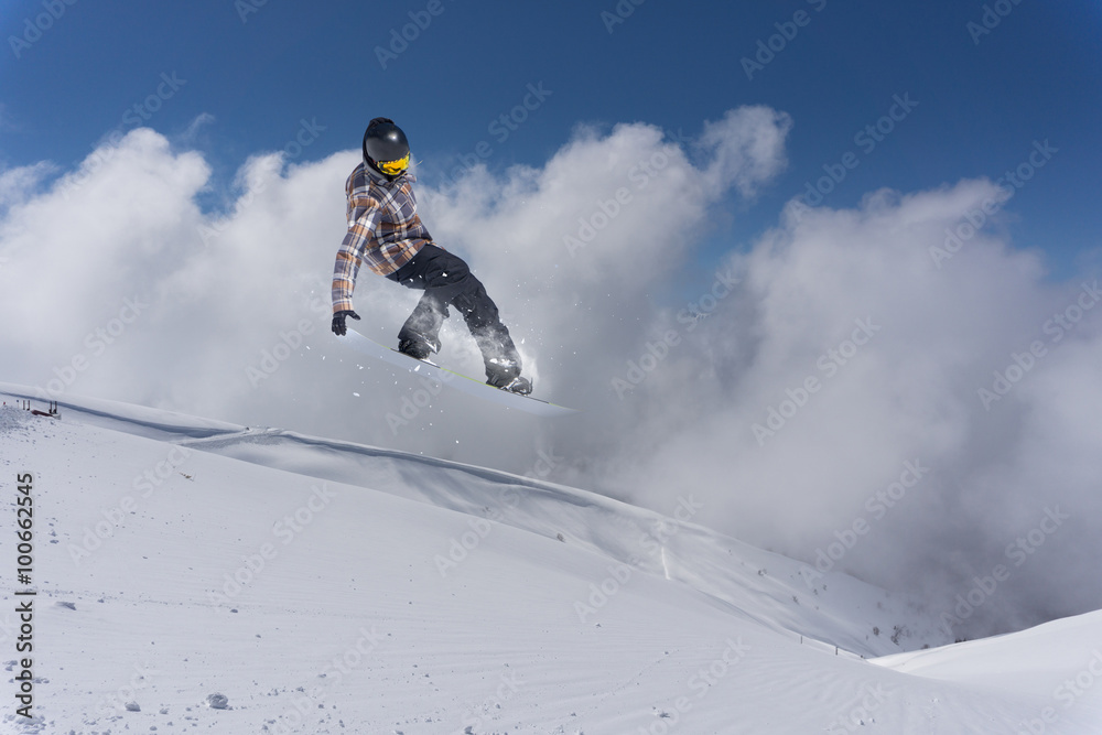 Flying snowboarder on mountains. Extreme sport.