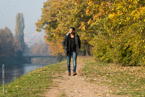 Attractive Man Walking In Autumn Forest © Jale Ibrak