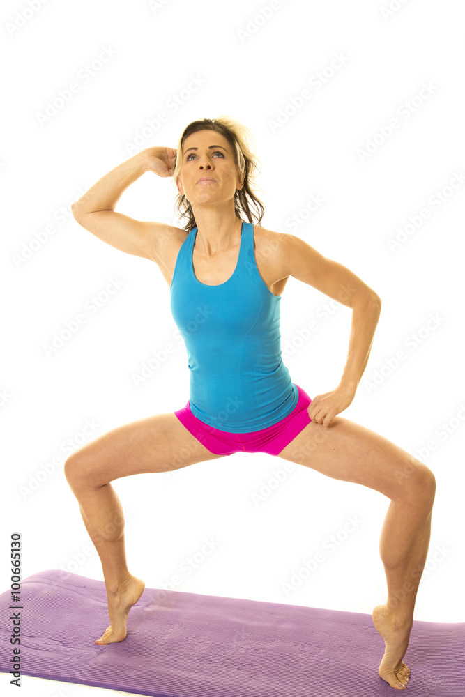 woman blue tank and pink shorts fitness squat on toes look up woman blue tank and pink shorts fitness squat on toes look up
