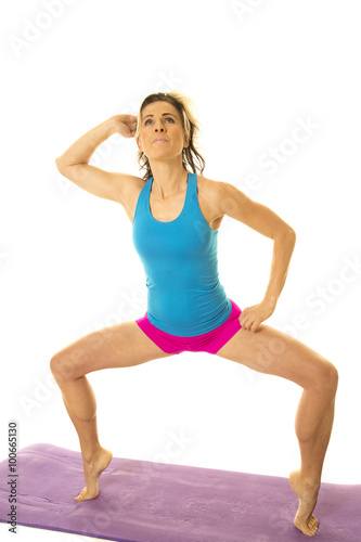 woman blue tank and pink shorts fitness squat on toes look up