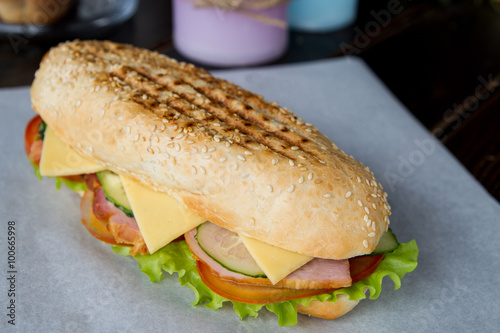 delicious sandwich with shank , cheese, tomato , lettuce and cuc