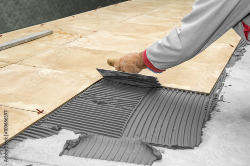 Photography Home improvement, renovation - construction worker tiler is tiling, ceramic tile