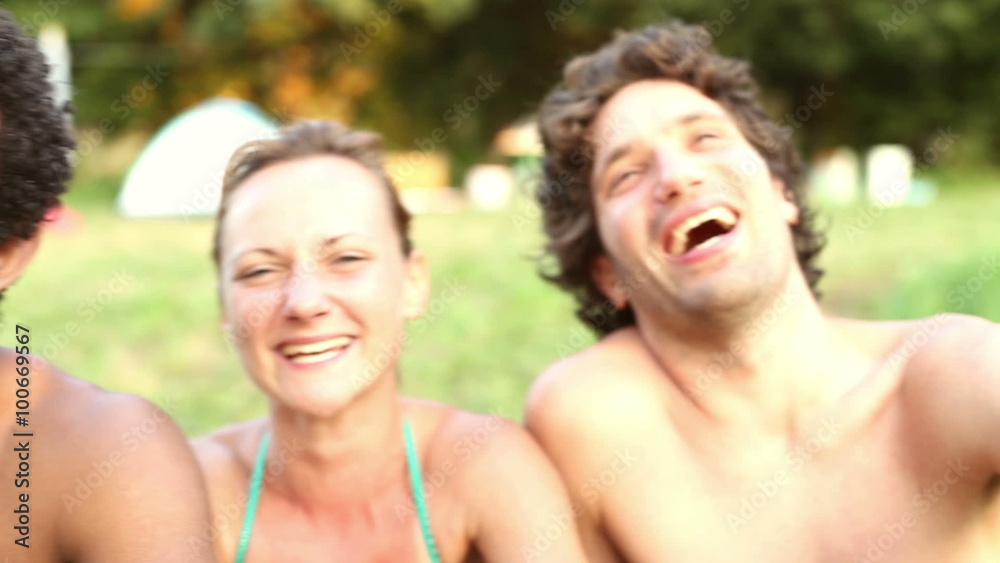 Portrait of group of friends sitting in nature, laughing at camera Portrait of group of friends sitting in nature, laughing at camera