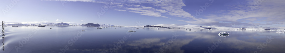 Clouds reflecting in calm seas of Antarctic Sound on sunny day.