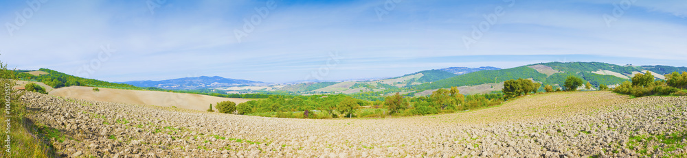 Tuscan countryside with plowed fields on foreground - Panoramic image