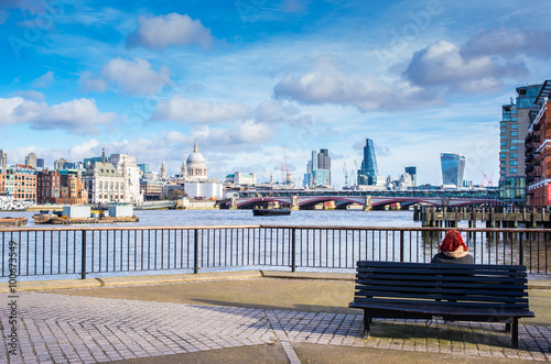 Tourist sitting down on bench admiring iconic London view photo