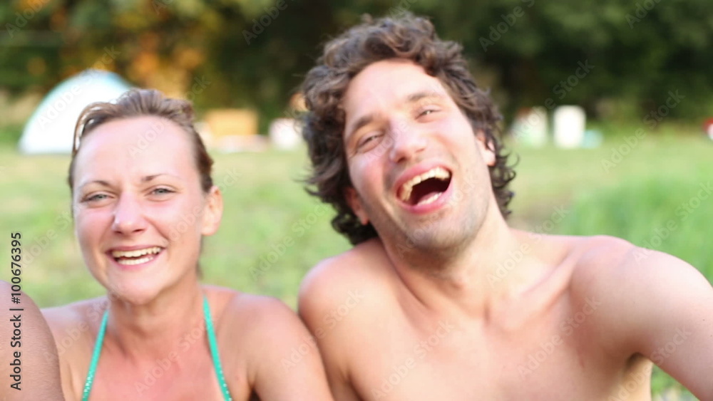 Portrait of group of friends sitting in nature, laughing at camera
