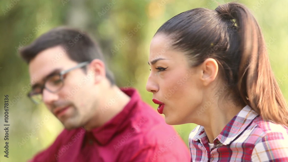 Young brunette woman singing while man sitting next to her playing guitar Young brunette woman singing while man sitting next to her playing guitar