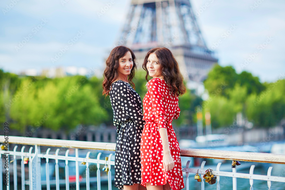 Beautiful twin sisters in front of the Eiffel tower