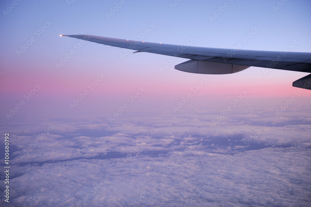 pink dawn light on the cloud under the airplane wing pink dawn light on the cloud under the airplane wing