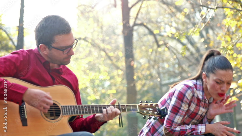 Man playing guitar while woman singing Man playing guitar while woman singing