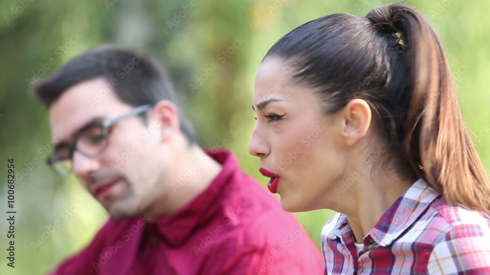 Young brunette woman singing while man sitting next to her playing guitar Young brunette woman singing while man sitting next to her playing guitar