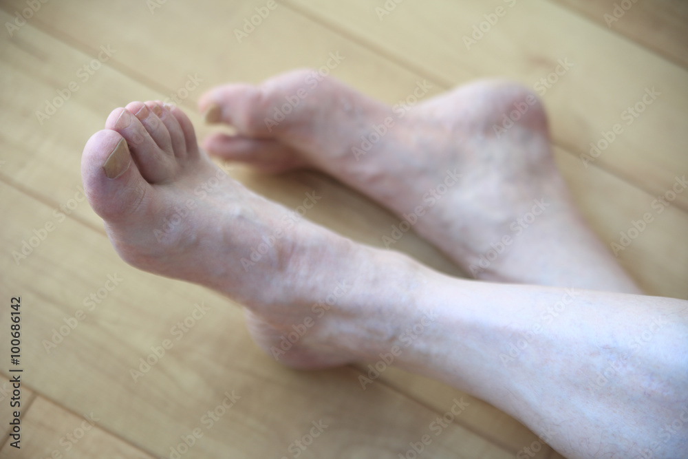 Senior man crosses legs on floor Senior man crosses legs on floor