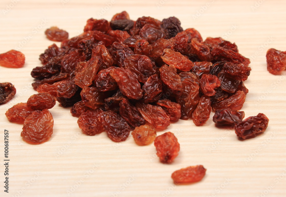 Brown raisins on wooden table, healthy eating Brown raisins on wooden table, healthy eating