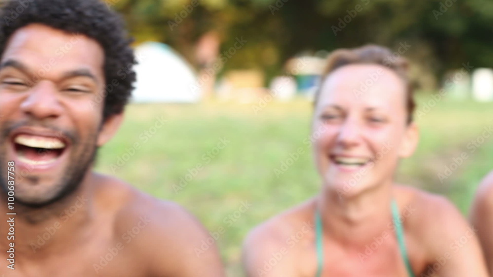 Portrait of group of friends sitting in nature, laughing at camera Portrait of group of friends sitting in nature, laughing at camera