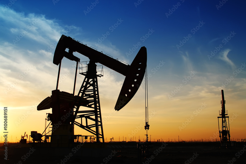 Oil field scene, the evening of beam pumping unit in silhouette Oil field scene, the evening of beam pumping unit in silhouette