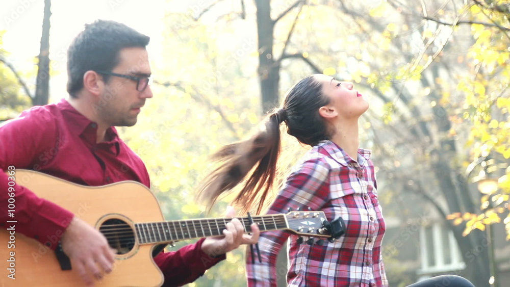 Man playing guitar while woman singing Man playing guitar while woman singing