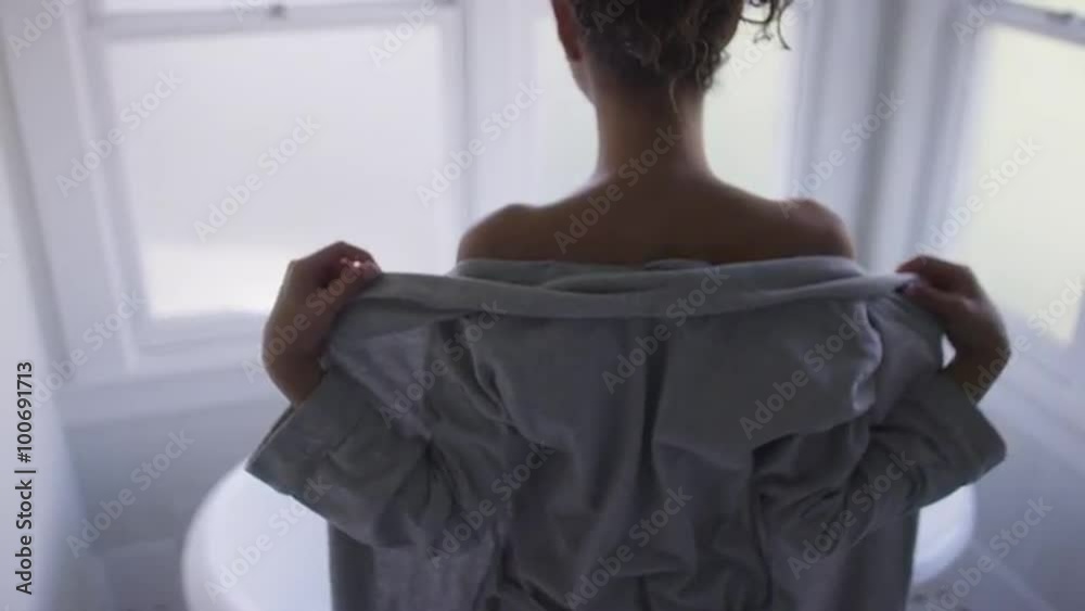 Beautiful young mixed ethnic woman undressing by bathtub