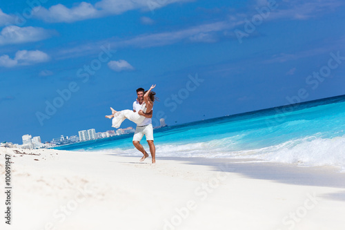 Happy newlyweds having fun on beach