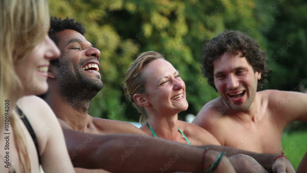 Four friends laughing while sitting in nature Four friends laughing while sitting in nature