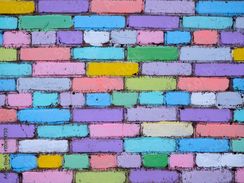 Multi-colored wall of bricks painted by children	